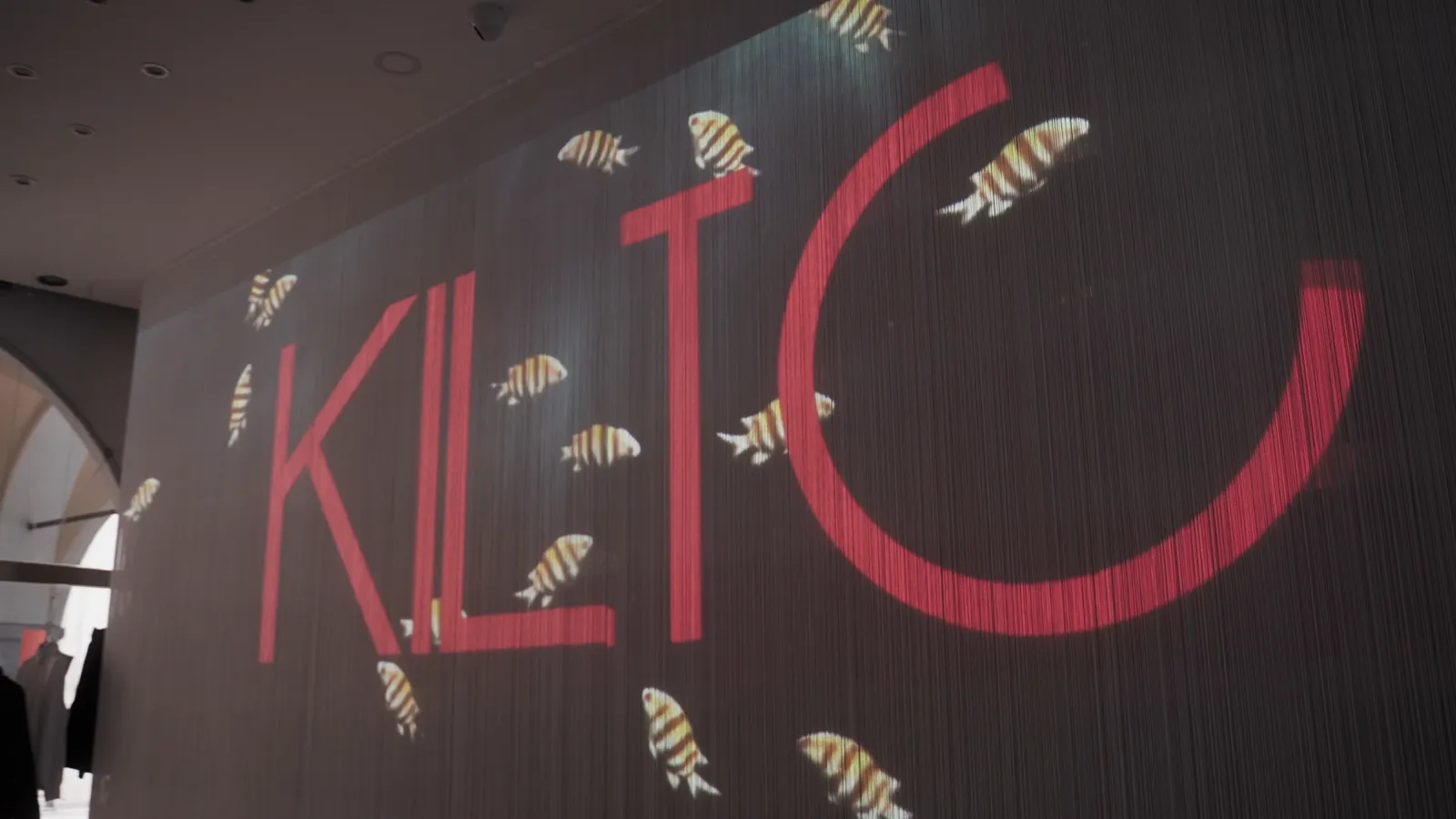 Fish and logo projected onto pleated curtains